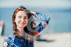 Portrait woman sea. Well looking middle aged woman with black hair, fitness instructor in blue swimwear near the sea