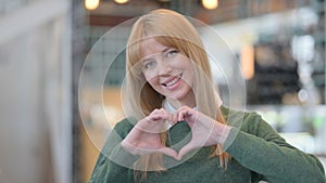 Portrait of Woman showing Heart Shape by Hands