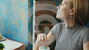 Portrait of a woman sitting in a cafe and drinking coffee