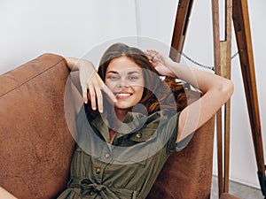 Portrait of a woman sitting on an orange sofa lying at home, rest and sleep, yawning, happy vacation home vacations