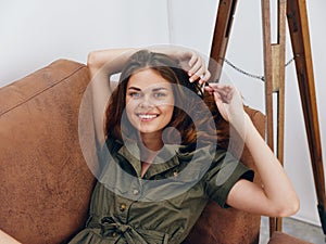 Portrait of a woman sitting on an orange sofa lying at home, rest and sleep, yawning, happy vacation home vacations