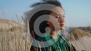 Portrait woman sitting sand looking camera. Dreamy girl enjoying landscape.