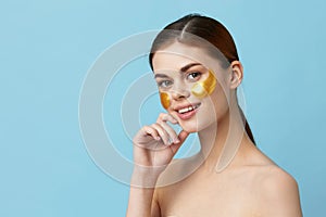 portrait woman skin care face patches bare shoulders hygiene blue background