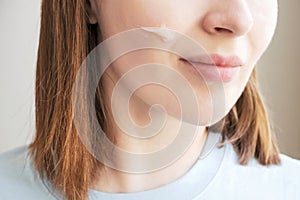 Portrait of a woman with smear moisturizer on her face close-up.