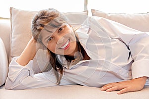 Portrait of woman smiling and lying in the sofa