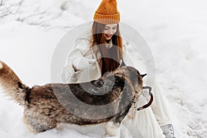 portrait of a woman in the snow playing with a dog fun friendship fresh air