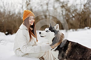 portrait of a woman in the snow playing with a dog fun friendship fresh air