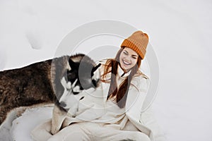 portrait of a woman in the snow playing with a dog fun friendship fresh air