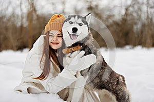 portrait of a woman in the snow playing with a dog fun friendship winter holidays