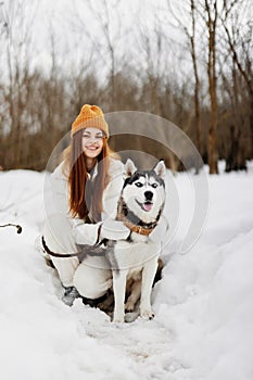 portrait of a woman in the snow playing with a dog outdoors friendship fresh air