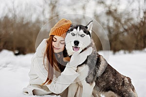 portrait of a woman in the snow playing with a dog outdoors friendship fresh air