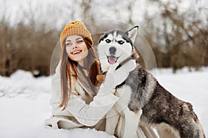 portrait of a woman in the snow playing with a dog outdoors friendship fresh air