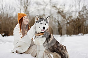 portrait of a woman in the snow playing with a dog outdoors friendship Lifestyle