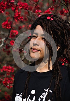 Portrait of woman standing against blooming flowers