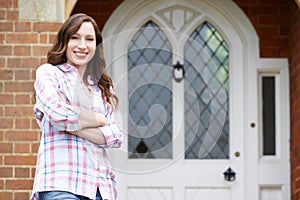 Portrait Of Woman Standing Outside Front Door Of Home