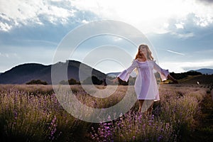 Portrait of woman is standing among the plantations of lavender