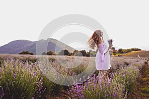 Portrait of woman is standing among the plantations of lavender