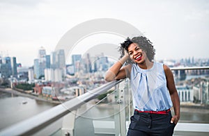 A portrait of a woman standing on a terrace in London. Copy space.