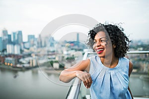 A portrait of a woman standing on a terrace in London. Copy space.