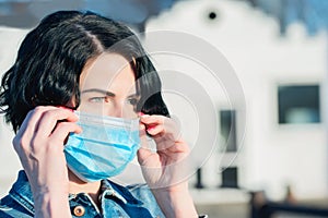 Portrait of woman on the street wearing protective mask as protection against infectious diseases, flu or covid