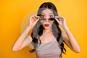 Portrait of woman in stupor putting her sunglass spectacles down to look at you with lips pouted pomaded isolated vivid photo