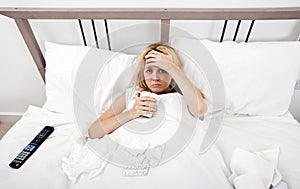 Portrait of woman suffering from cold having coffee in bed