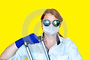 Portrait of woman in sunglasses and medical mask on yellow background. Tourism 2020 concept.