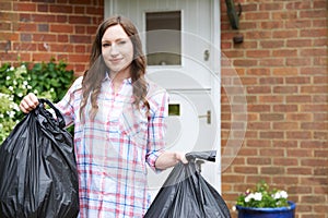 Portrait Of Woman Taking Out Garbage In Bags