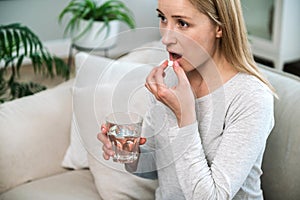 Portrait of woman taking pill, daily medicines, medication for headache