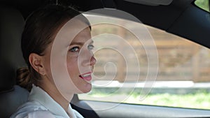 Portrait of woman talking on speakerphone in car