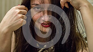 Portrait of a woman with tangled hair looking at the camera.