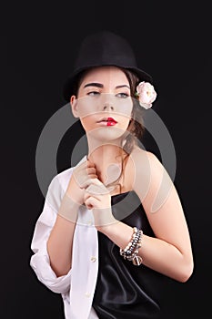 Portrait of the woman with a theatrical makeup on black background