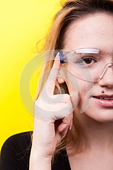 Portrait of woman touching a button on futuristic smartglasses