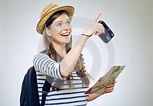 Portrait of woman traveler with camera and paper map pointing finger
