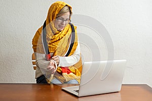 Portrait of woman, UAE national flag, laptop