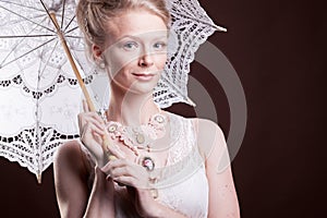 Portrait of woman in vintage dress holding a lace umbrella