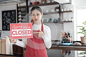 Portrait of woman waitress standing at her coffee shop gate