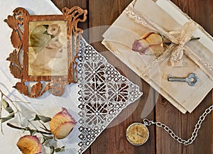 Portrait of a woman wearing a hat in an openwork frame, dried roses and a pile of letters. Retro composition