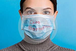 Portrait of a woman wearing medical mask with China quarantine word at blue background. and healthcare concept