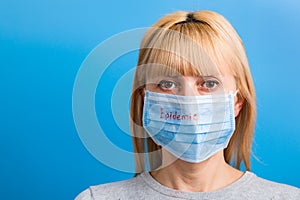 Portrait of woman wearing medical mask with epidemic word at blue background. Protect your health. concept