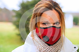 Portrait of woman wearing protective red fabric face mas to guard against virus.