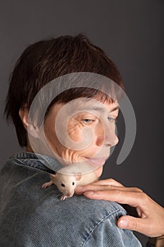 Portrait of woman with white baby rat