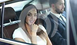 Portrait of a woman in a white dress in her car in the back seat