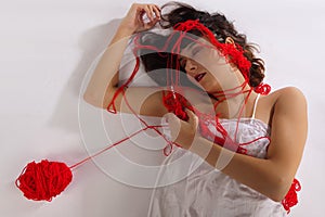 Portrait woman white silk nightie laying white floor red woolen thread sleeping