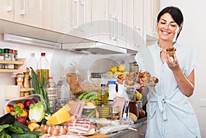 Portrait of woman who is holding cupcakes that she buyed in market.