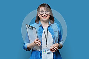 Portrait of woman worker with industrial center card clipboard, on blue background