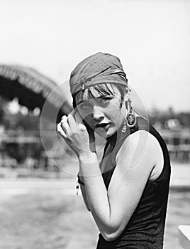 Portrait of a woman wrapping a scarf on her head