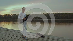 Portrait of a Woman with a Yoga Mat on the Background of the Morning River