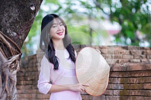 Portrait women in pink ao dai Vietnam and holding straw hats, The Ao dai