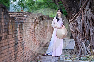 Portrait women in pink ao dai Vietnam and holding straw hats, The Ao dai ( long-dress Vietnamese)